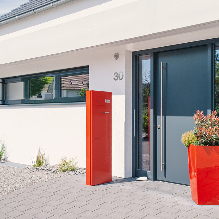 Orange Briefkasten Säule am Eingang eines Einfamilienhauses 